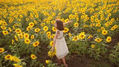 夏天向日葵田野上快乐的小女孩.. 向日葵上美丽的小女孩。 慢动作视频。 女孩